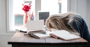 机に伏せる女性